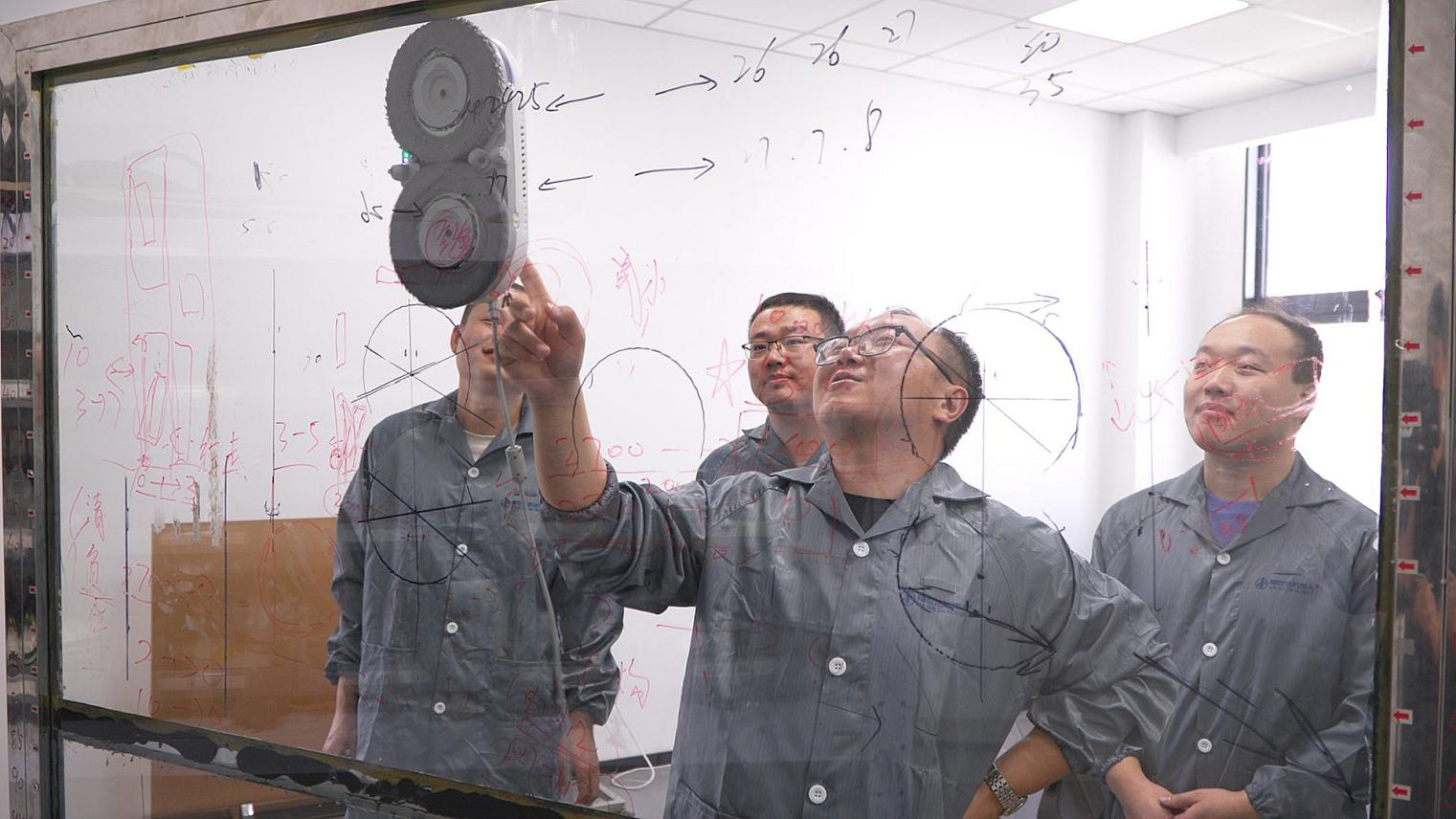 工程師們正在討論擦窗機器人的行走路徑。受訪企業供圖