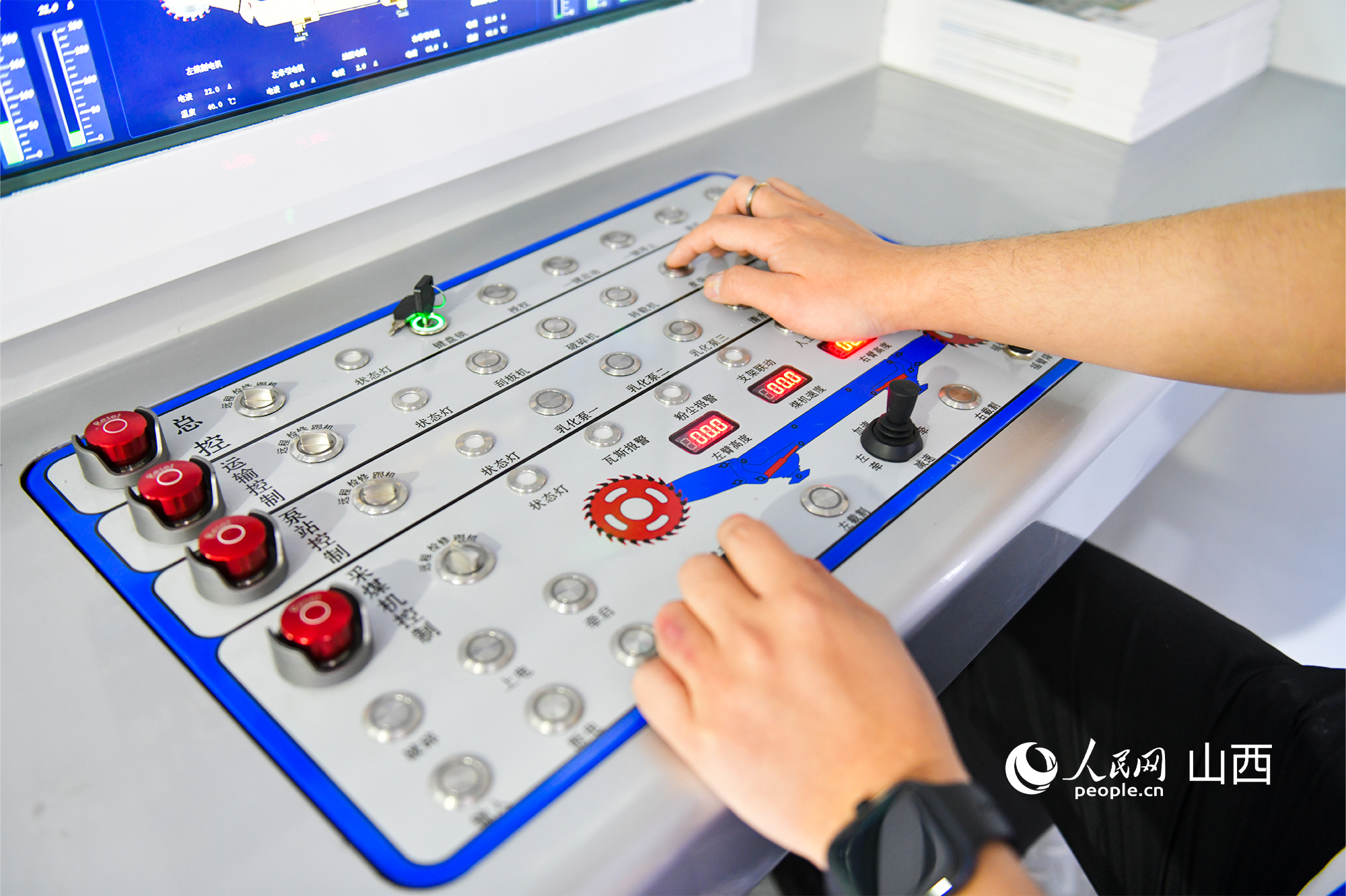 晉能控股展臺，工作人員模擬操作云智能綜采物聯集控系統。