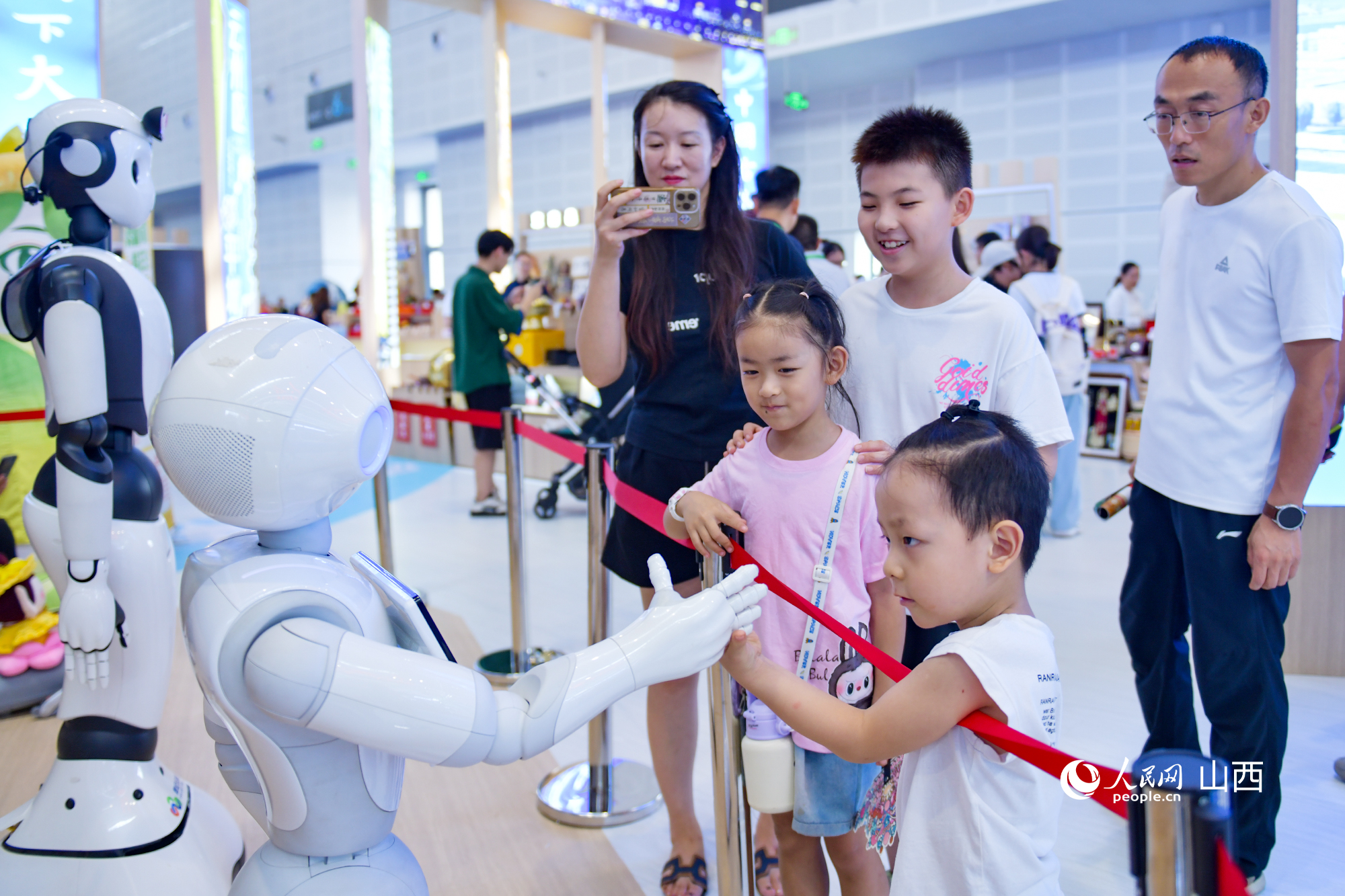 小觀眾和機器人聊天“交朋友”。人民網記者 焦搏文攝