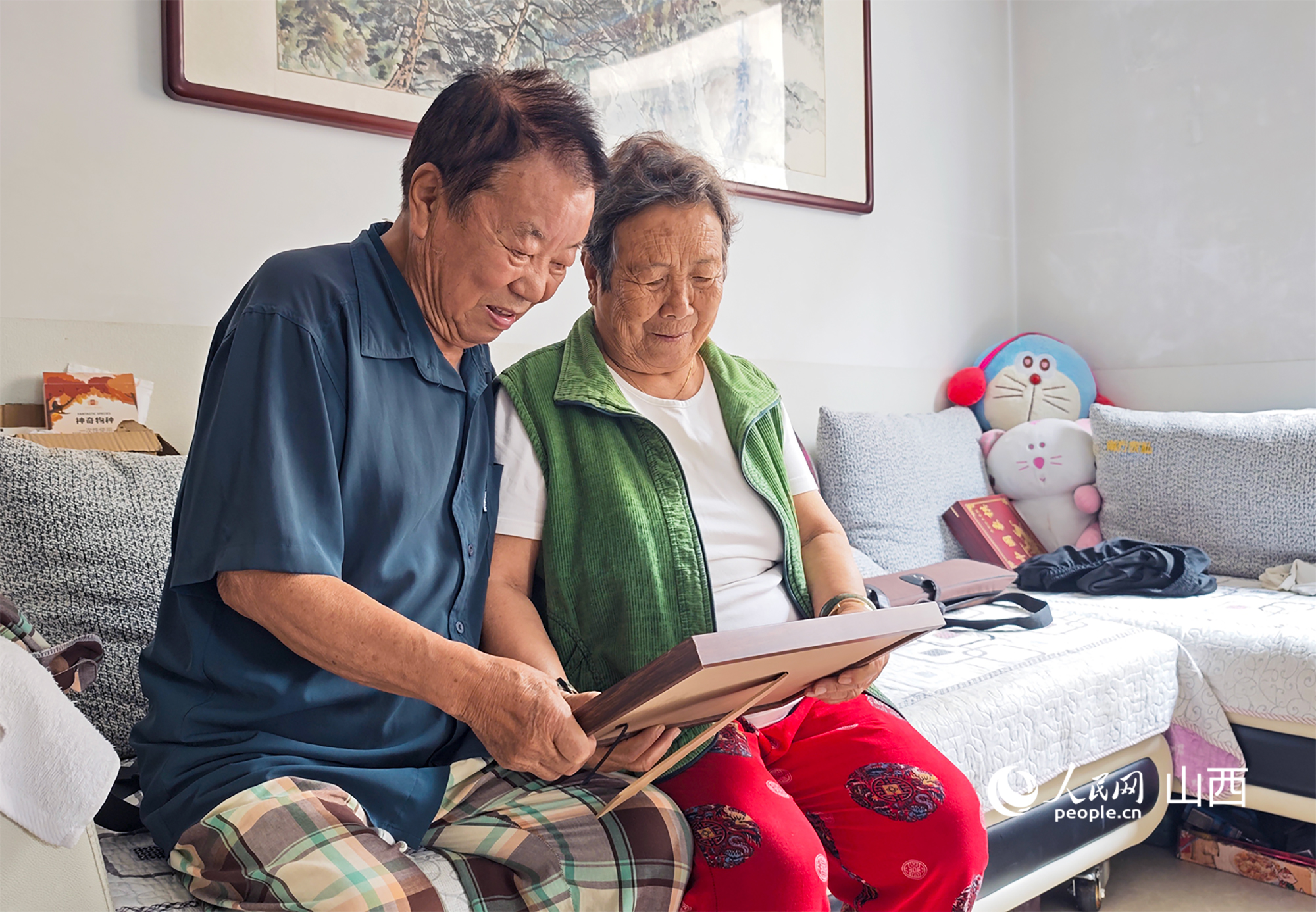 兩位老人拿到婚紗照看了又看。人民網記者 焦搏文攝